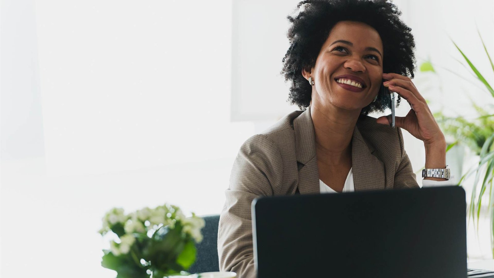 Smiling professional on a phone call at an office desk