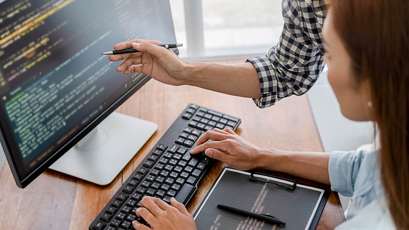Web developers writing code at a computer